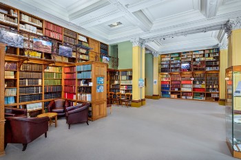 period library with bookshelves floor to ceiling and leather seating